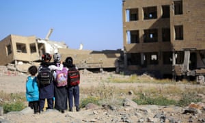 Yemeni children look at a school badly damaged in Saudi-led coalition airstrike in the southern city of Taez.
