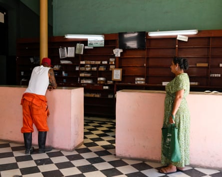 two people wait at a counter in a pharmacy