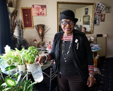 Tee watering plants in her living room
