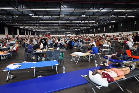 A large exhibition centre with people lying in beds