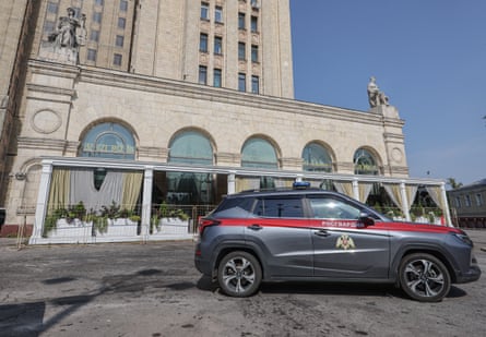 A national guard car stands outside an empty restaurant with outdoor seating