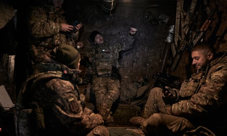 Ukrainian soldiers hide in a dugout in the Bakhmut district, Ukraine