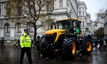 JCB tractor and policeman on wet city street