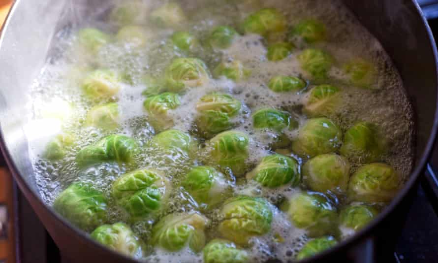 brussels sprouts cooking in in a saucepan of boiling water
