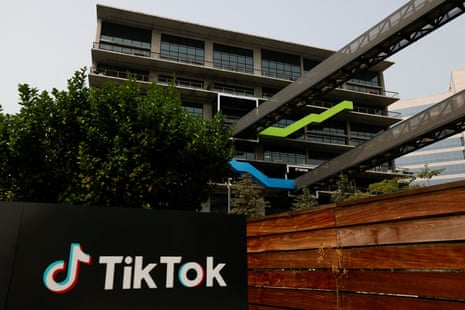 A sign in front of an office building bears the TikTok logo.