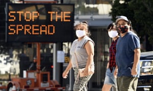 People wearing masks in front of a coronavirus sign are urging citizens to