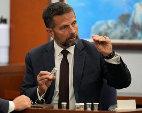 Dean O'Kelley, a Las Vegas police officer who attended the scene of shooting, holds shell casings as he testifies during the murder trial of Duane Davis, related to the 1996 killing of rapper Tupac Shakur, at the Clark County District Court at the Regional Justice Center in Las Vegas, Nevada, on 18 August.