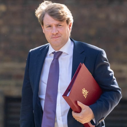 Chris Skidmore walks, clutching a red ministerial folder.