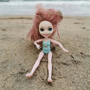 A plastic doll on the beach.