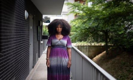 Assa Traoré outside her home in Ivry, a southern suburb of Paris, wearing a long, glittery purple and silver striped dress