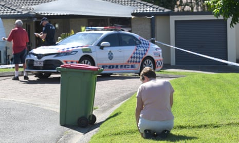 Arundel resident Louise Christy is seen kneeling in mourning outside the home of murder victim Kelly Wilkinson on the Gold Coast, Australia