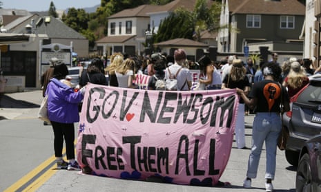 Two women hold up a banner urging California governor Gavin Newsom to free prisoners during a news conference outside San Quentin State Prison Thursday, July 9, 2020