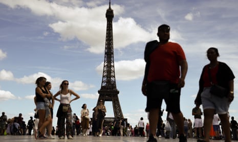 People stand near the Eiffel tower at Place Trocadero in Paris, France on 12 August 2023. 
