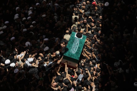The coffin of the late Iranian supreme lleader Ayatollah Ali Khamenei is carried by mourners to the Imam Ali Shrine in Najaf, Iraq, on 8 July.