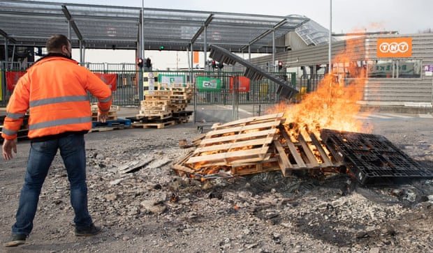 Workers build a protest fire at the entrance of the FedEx/TNT facility near Liège airport.