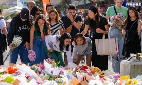 Members of the public add flowers to the expanding mass near the crime scene at Bondi Junction in Sydney, where six people were stabbed to death at Westfield Shopping Centre on Saturday.