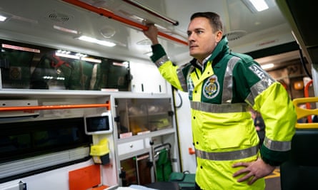 Wes Streeting dressed in paramedic’s hi-vis green and yellow jacket, standing in the back of an ambulance