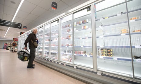 A shopper stares at empty shelves of the Co-op meat aisle in Harpenden, Hertfordshire.