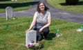 A woman kneeling on the grass by a small white marble grave for Zoe Karen Gentle