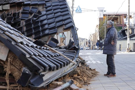 Een man staat voor een verwoeste kaarsenwinkel na de aardbeving in Nanao, in de prefectuur Ishikawa.