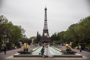 A couple pose in front of a replica of the Eiffel Tower