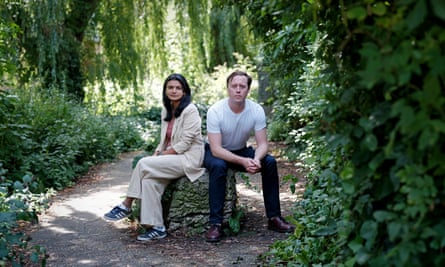 Areeba Hamid and Will McCallum sit on a stone plinth in a forest