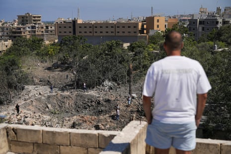 A man looks at the site of a bombing from the roof of a building.