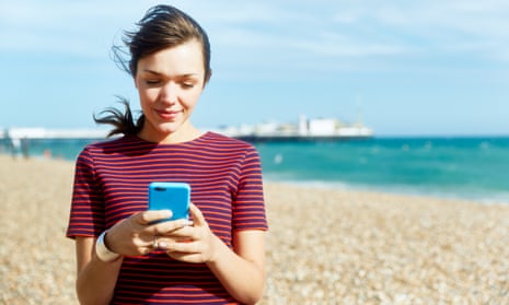 Woman using smart phone on beach