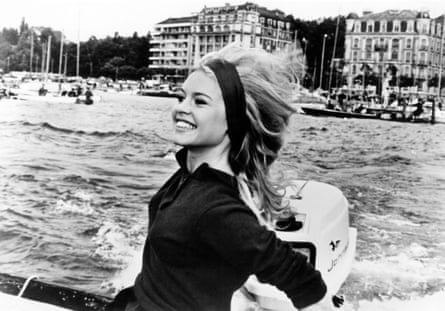Bardot in black headscarf and black top on a speedboat in France