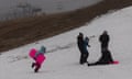Tourists play on patches of man-made snow at Perisher in the NSW Snowy Mountains