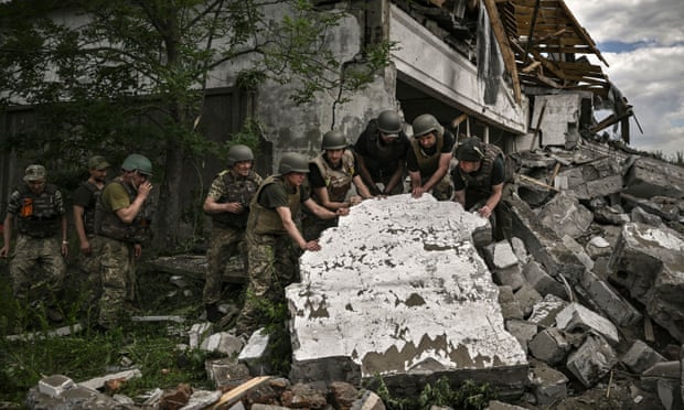 Ukrainian soldiers inspect a destroyed warehouse reportedly targeted by Russian troops in Lysychansk, eastern Ukrain
