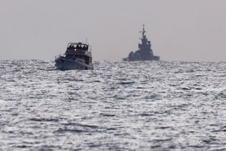 A vessel bearing symbols of the Global Sumud Flotilla with an Israeli military ship behind it, seen from Ashdod, southern Israel on 19 May