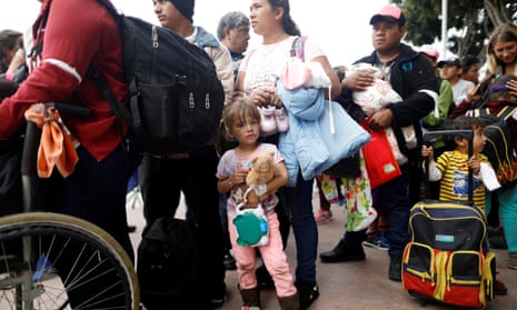 People from the caravan wait at the San Ysidro border crossing in Tijuana, Mexico.