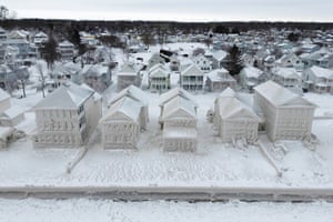 Houses along the shores of Lake Erie remain covered in ice following a winter storm that swept through much of Ontario