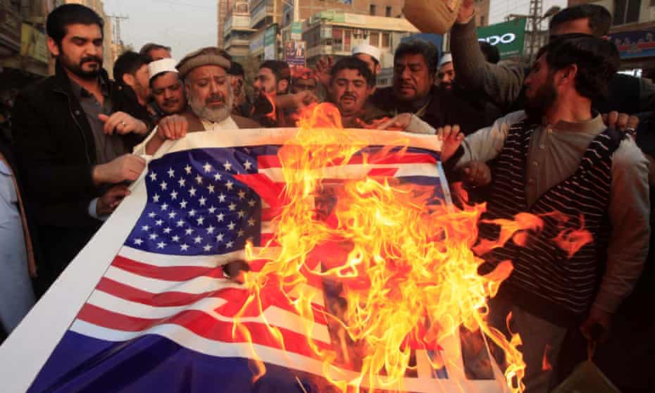 People burn an image of the US flag next to Donald Trump during an anti-US protest in Peshawar on Firday.