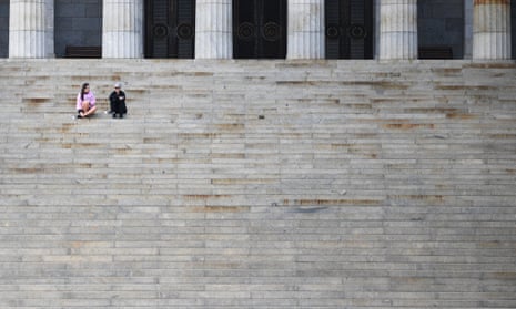 People are seen sitting on the staircase at the Shrine of Remembrance in Melbourne