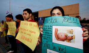 A woman holds a sign that reads “Stop now” during a protest against child sexual abuse, Paraguay