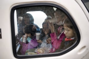 Children drink and eat in back of motorcycle taxi