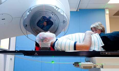 Radiotherapy radiographer with a male patient treated for a brain cancer with radiotherapy