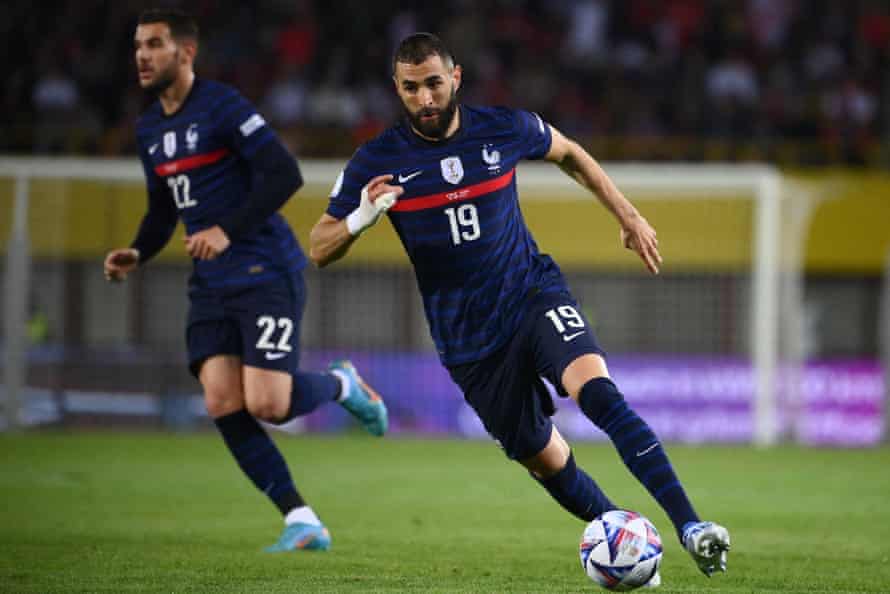 France’s forward Karim Benzema (R) runs with the ball.