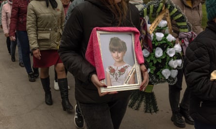 A woman carries a portrait of a child Uliana Troichuk (8), killed during the Russian attack on a residential building, during her funeral on 30 April 2023 in the village of Apolyanka, outside Uman, Ukraine.