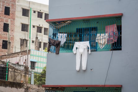 A white protective suit is among the laundry hanging from the veranda of an apartment belonging to a neighbour of the photographer