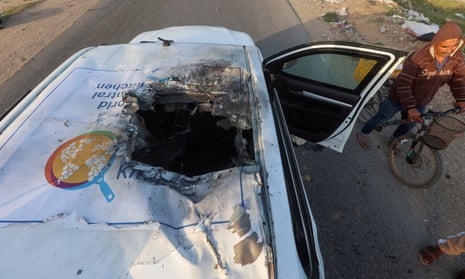 A Palestinian man on a bicycle passes a damaged vehicle where employees from the World Central Kitchen (WCK) were killed in an Israeli airstrike, according to the NGO as the Israeli military said it was conducting a thorough review at the highest levels to understand the circumstances of this "tragic" incident, amid the ongoing conflict between Israel and Hamas, in Deir Al-Balah, in the central Gaza, Strip April 2, 2024.