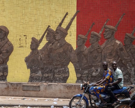 A motorcyclist rides past a monument in support of the Malian Army in Bamako on April 26, 2026.