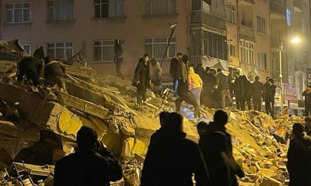 Des habitants fouillent les décombres d'un immeuble détruit par le tremblement de terre en Turquie.