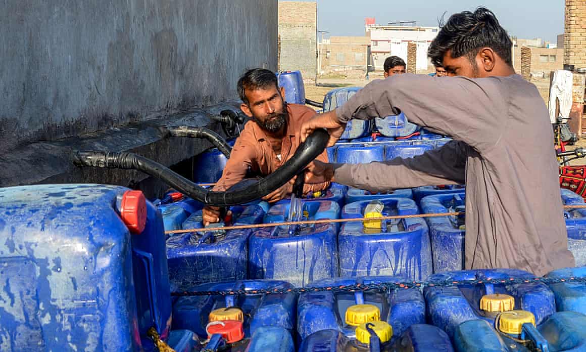 Vendors fill cans with drinking water from a private water supply plant in Jacobabad, Pakistan