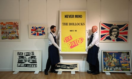Gallery assistants hanging Jamie Reid’s promotional poster for the 1977 album Never Mind the Bollocks, at a preview for a Sotheby’s auction of Sex Pistols memorabilia n 2022.