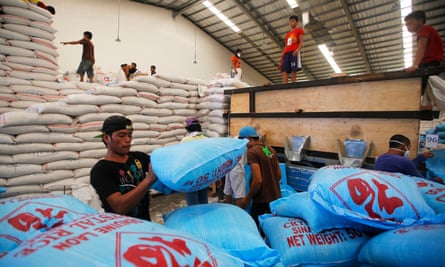 Filipino workers prepare for the distribution of aid at a relief centre