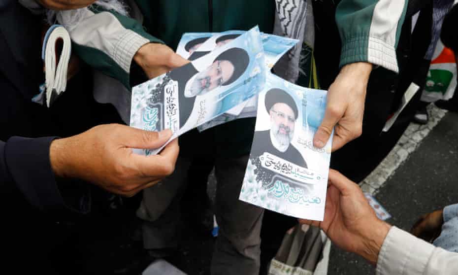 Iranian campaign workers distribute electoral posters Ebrahim Raisi.