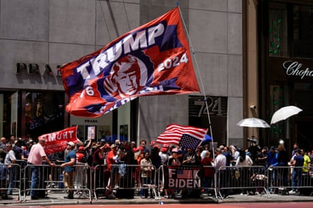 People with Trump flags on urban street.